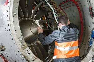 ai generado ver desde el espalda de aeronave mantenimiento técnico trabajando en turbina foto