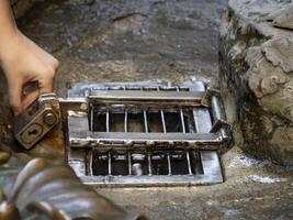 Detail of Hand touching good luck copper pig statue in Florence rite of fortune you have to rub a coin on the nose of wild boar and then drop it into the manhole cover of the porcellino fountain photo