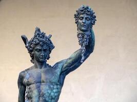 Detail of Perseus holding head of Medusa, bronze statue in Loggia de Lanzi, Piazza della Signoria, Florence, Italy. Isolated on white photo