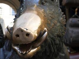 detalle de mano conmovedor bueno suerte cobre cerdo estatua en florencia rito de fortuna usted tener a frotar un moneda en el nariz de salvaje Jabali y luego soltar eso dentro el agujero de hombre cubrir de el porcellino fuente foto