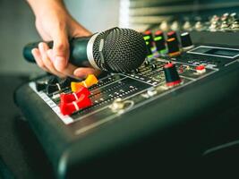 Hand Sound engineer  holding microphone on sound mixer in live broadcasting studio producer for sound record control system production and audio equipment and music instrument photo