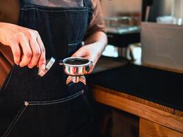 primer plano de la cafetería barista manual haciendo café con prensas manuales café molido usando tamper en la cafetería foto
