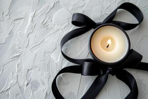 AI generated A candle encircled by a black ribbon, resting on a white table photo