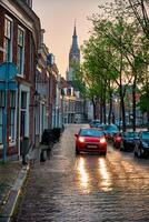 Delft cobblestone street with car in the rain photo