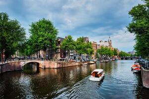 Amsterdam view   canal with boad, bridge and old houses photo