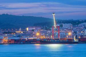 View of Lisbon port with ship and port cranes in the evening photo
