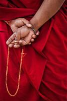 Tibetan Buddhism concept - buddhist monk hands with prayer beads close up photo