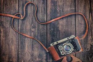 Old retro vintage camera on grunge wooden background photo