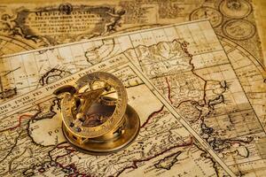 Old vintage compass on ancient map photo