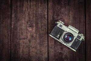 Old retro vintage camera on grunge wooden background photo