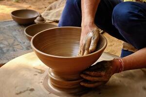 Indian potter at work, Shilpagram, Udaipur, Rajasthan, India photo