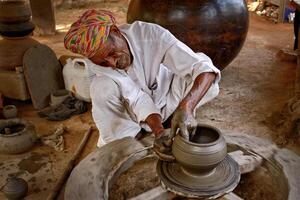 Indian potter at work, Shilpagram, Udaipur, Rajasthan, India photo