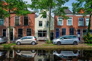 Cars on canal embankment in street of Delft. Delft, Netherlands photo