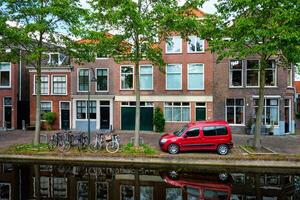 Cars on canal embankment in street of Delft. Delft, Netherlands photo