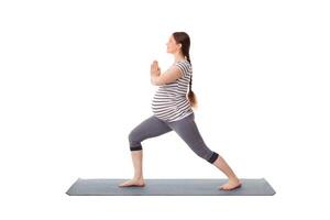 Pregnant woman doing yoga asana Virabhadrasana 1 isolated photo