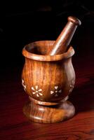 Wooden mortar and pestle on dark photo