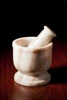 Marble mortar and pestle on dark photo