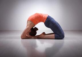 Beautiful sporty fit yogi girl practices yoga asana Kapotasana photo