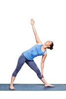 Woman doing yoga asana utthita trikonasana   extended triangle pose photo