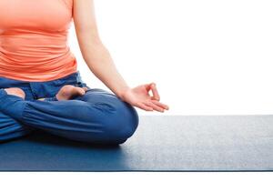 Close up of woman in yoga asana Padmasana Lotus pose photo