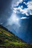 Sun rays through clouds in Himalayan valley in Himalayas photo