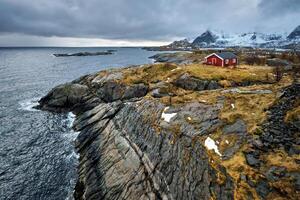 Clif con tradicional rojo rorbu casa en lofoten islas, Noruega foto