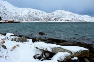 noruego fiordo con rojo rorbu casas en Noruega en invierno foto