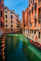 Narrow canal with gondola in Venice, Italy photo