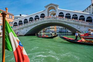 Italian maritime flag with Rialto bridge with gondolas in the bacground. Grand Canal, Venice, Italy photo