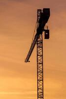 Building crane silhouettes in sky photo