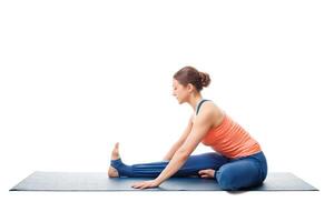 Woman doing Ashtanga Vinyasa Yoga asana Janu sirsasana photo