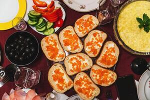 Homemade festive lunch with sandwiches, red caviar, butter, olives photo