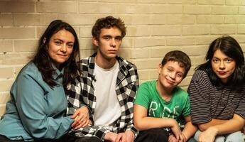 Mother and three kids enjoying a birthday party on the couch in their cozy home photo