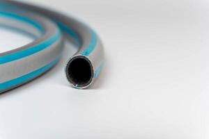 Flexible pvc garden hose coiled on white background with copy space photo