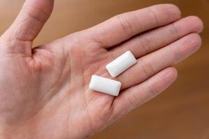 Maintaining fresh breath and oral health with two chewing gum pads on woman's palm photo