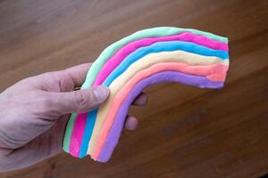 Colorful rainbow craft project made with thermoplastic on wooden background photo