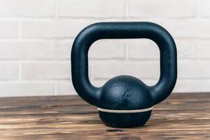 A modern fitness kettlebell On a wooden table. the concept of a healthy lifestyle. physical development photo