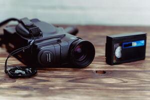 vintage analog VHS video camera and a cassette with film on a wooden table photo