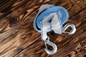 car tow rope with hooks. A rolled-up blue and white rope lying on a wooden table. photo