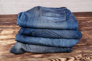 Stack of Jeans on Wooden Table photo