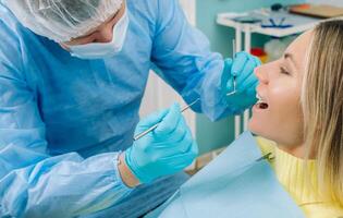 The patient treats her teeth at the dentist in the dental office . Dental fillings photo