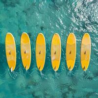 ai generado un conjunto de amarillo tablas de surf en un azul mar antecedentes foto