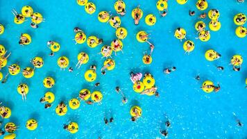 parte superior ver de personas relajante en el piscina en amarillo inflable círculos foto