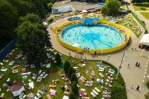 Top view of an outdoor place for people to relax where there is a swimming pool and a lot of sun beds photo