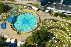 Top view of an outdoor place for people to relax where there is a swimming pool and a lot of sun beds photo