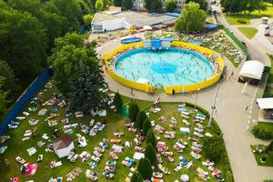 Top view of an outdoor place for people to relax where there is a swimming pool and a lot of sun beds photo