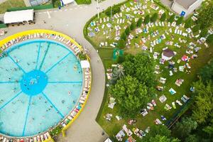Top view of an outdoor place for people to relax where there is a swimming pool and a lot of sun beds photo