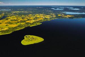 Love island on a lake in Europe, a Green heart-shaped Island on a dark lake with a sparkle from the sun photo