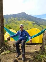 Mojokerto, Indonesia, 04 Nov 2020 - A man sits in a hammock on Mount Pundak, Mojokerto photo