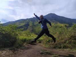 Mojokerto, Indonesia, 04 November 2020 - A man jumps at the Mount Pundak resting place, Mojokerto photo